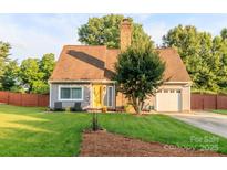 Charming home featuring a well-manicured lawn, freshly painted siding, and inviting, bright yellow front door at 10209 Green Tee Ln, Charlotte, NC 28277