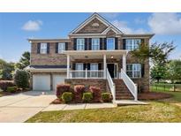 Charming brick two-story home featuring a welcoming front porch and well-manicured landscaping at 1090 Mclaren Dr, Belmont, NC 28012