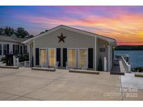 Charming lakeside cottage featuring a star decoration, inviting curb appeal, and serene waterfront views at 141 Badin Lake Cir, New London, NC 28127