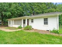 Charming single-story home featuring a white brick facade and a welcoming front porch at 2131 Lee St, Gastonia, NC 28054