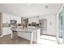Bright kitchen with white cabinets, stainless steel appliances, and a large island with a quartz countertop at 22 Honeysuckle Ln, Clover, SC 29710