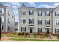 Charming two-story townhome with gray siding, black shutters, and well-maintained landscaping at 2203 Autumn Olive Ln, Stallings, NC 28104