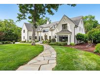 Elegant white brick home with a landscaped front yard and a stone walkway leading to the entrance at 2215 Cortelyou Rd, Charlotte, NC 28211