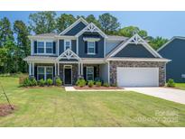 Charming two-story home with stone accents, manicured lawn, and a welcoming front porch at 250 Winford Rd, Troutman, NC 28166