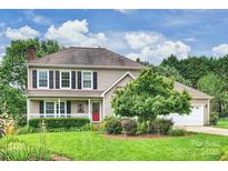 Charming two-story home with a well-manicured lawn, mature landscaping, and a welcoming front porch at 2525 Saddlehorse Ln, Gastonia, NC 28056