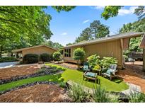 A peaceful backyard retreat with lovely landscaping and an inviting seating area for outdoor relaxation at 26 New River Trce, Lake Wylie, SC 29710