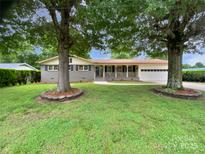 Charming single-story home with a welcoming front porch and mature trees shading the yard at 302 Melinda Ave, Kannapolis, NC 28083