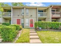 Inviting townhome with well-manicured front yard and vibrant red doors at 7912 Charter Oak Ln, Charlotte, NC 28226