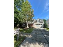 Charming two-story home with a well-manicured lawn, mature trees, and a two-car garage at 1304 Ridge Haven Rd, Waxhaw, NC 28173