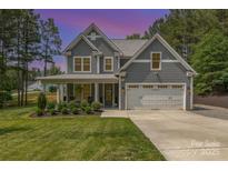 Charming two-story home with a well-manicured lawn, inviting front porch, and a two car garage at 148 Powder Spring Dr, Statesville, NC 28677