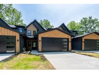 Modern townhome with a black and wood exterior, black garage doors, and concrete driveway at 1524 Enochville Rd, Kannapolis, NC 28081