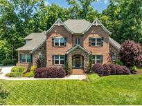 Beautiful brick and stone home with a manicured lawn and lush landscaping at 1600 Buckland Ct, Indian Land, SC 29707
