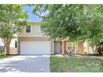 Charming two-story home featuring a two-car garage, a quaint front porch, and manicured landscaping at 1817 Tradd Ave, Clover, SC 29710