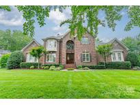 Brick two-story home featuring a manicured lawn and a symmetrical design, complete with mature landscaping at 2300 Richardson Dr, Charlotte, NC 28211