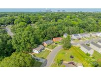 Overhead view of a neighborhood with mature trees and glimpse of the Charlotte skyline in the distance at 3608 Crestridge Dr, Charlotte, NC 28217