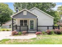 Charming home featuring a cozy porch, decorative railings, and well-maintained landscaping at 403 Weaver St, Cherryville, NC 28021
