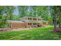 Charming two-story home with brick accents, a landscaped yard, and a welcoming front porch at 411 Saint Andrews Rd, Statesville, NC 28625