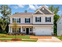 Charming two-story home with gray siding, black shutters, covered porch and a well-maintained landscaped front yard at 524 Hullview Vis, Monroe, NC 28110