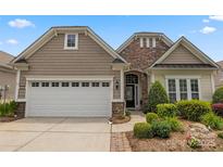 Charming home showcasing a manicured lawn, stone accents, and a white two-car garage door at 56113 Finches Ct, Indian Land, SC 29707