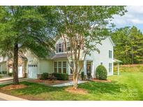 Charming home with manicured lawn, lush landscaping and neutral siding on a bright sunny day at 5963 Pale Moss Ln, Charlotte, NC 28269