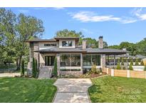 Stunning two-story home with stone accents, manicured lawn, and inviting entryway, showcasing modern design at 639 Edgemont Rd, Charlotte, NC 28211