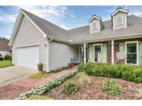 Charming home exterior with manicured landscaping, brick accents, and a welcoming entrance at 7526 Shadowstone Dr, Charlotte, NC 28270