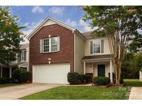 Charming two-story home with brick and siding, attached garage and well-manicured lawn at 7623 Monarch Birch Ln, Charlotte, NC 28215