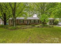 Charming brick home with green shutters, a well-manicured lawn, and mature trees at 1005 Fieldstone Rd, Mooresville, NC 28115