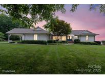 Stunning one-story home with lush front yard and a charming porte cochere on a spacious lot at 22501 John Gamble Rd, Cornelius, NC 28031