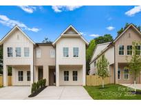 Charming new construction home with modern farmhouse-style, inviting curb appeal, and concrete driveway at 2413 Pruitt St, Charlotte, NC 28208