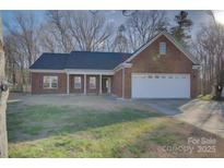 Charming brick home with a well-manicured lawn and attached two-car garage at 2712 Thornburg Ct, Monroe, NC 28110