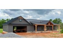 New construction home features board and batten siding and a covered front porch at 3000 Paul Payne Store Rd, Taylorsville, NC 28681