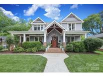 Charming home with a welcoming front yard, featuring lush landscaping and classic architectural details at 3237 Sunset Dr, Charlotte, NC 28209