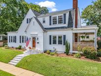 Charming two-story home with white siding, black shutters, an American flag and manicured lawn at 329 E Congress St, Lincolnton, NC 28092
