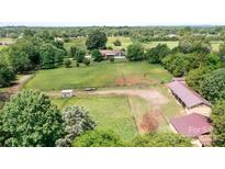 Expansive aerial view of property featuring a residence and lush surrounding landscape with mature trees at 4026 Biggerstaff Rd, Maiden, NC 28650