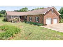 Charming brick home featuring an attached two car garage and a well-maintained front lawn at 4026 Biggerstaff Rd, Maiden, NC 28650
