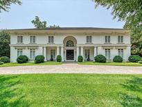 Stately two-story home features a symmetrical facade, manicured landscaping, and a circular driveway at 4300 Cameron Oaks Dr, Charlotte, NC 28211