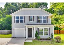 Charming two-story home featuring gray siding, symmetrical windows with dark shutters, and a one car garage at 672 Carybrook Ct, York, SC 29745