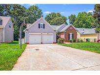 Charming home featuring a two-car garage, a well-maintained lawn, and a basketball hoop for recreational activities at 7033 Spandril Ln, Charlotte, NC 28215