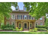 Elegant brick home featuring a charming balcony, manicured lawn, and tasteful landscaping at 7319 Stonehaven Dr, Waxhaw, NC 28173