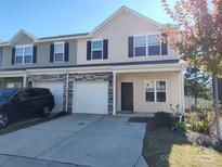 Charming townhome featuring stone accents, attached garage, and a well-maintained front yard at 7323 Jane Parks Way, Charlotte, NC 28217