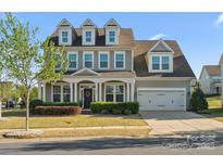 Charming two-story home featuring a welcoming front porch, manicured lawn, and attached two car garage at 1001 Hampton Grove Rd, Waxhaw, NC 28173