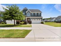 Charming two-story home with a manicured front lawn and a spacious two-car garage at 207 Welcombe St, Mooresville, NC 28115