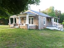Charming stone cottage featuring a covered porch and well-maintained lawn at 209 14Th Se Ave, Hickory, NC 28602