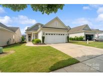 Charming home featuring a well-manicured lawn, neat landscaping, and an attached two-car garage at 23117 Whimbrel Cir, Fort Mill, SC 29707