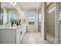 Bright bathroom featuring double vanity, stylish fixtures, and a glass-enclosed shower with tile surround at 3124 Beacon Heights Rd, Indian Land, SC 29707