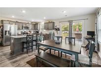 The kitchen features gray cabinets, stainless steel appliances, and an island with seating adjacent to the dining area at 3401 Shillinglaw Rd, Sharon, SC 29742