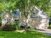 Charming two-story home with an attached two-car garage and a beautifully landscaped front yard filled with mature trees at 3415 Crescent Knoll Dr, Matthews, NC 28105