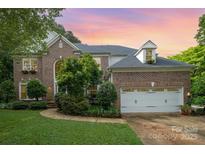 Charming brick home with a two-car garage, manicured lawn, and tasteful landscaping at 8219 Beardsley Dr, Charlotte, NC 28269