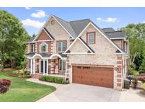Beautiful two-story brick home with a well-manicured lawn, large two-car garage, and charming front porch at 9112 Butterfly Ct, Gastonia, NC 28056
